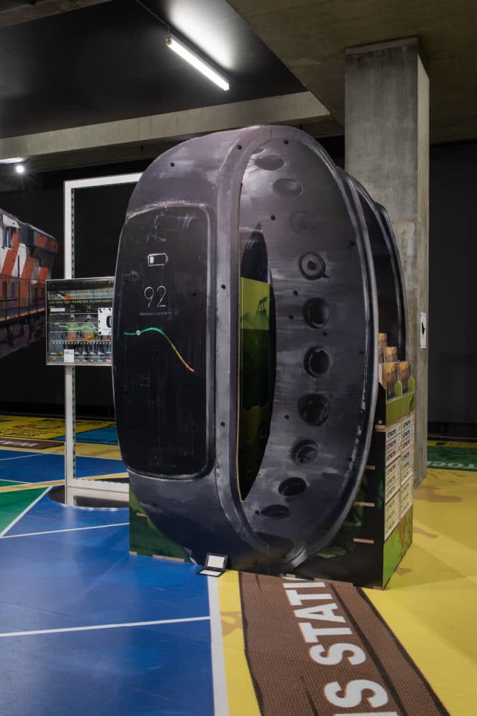 Simon Denny, "Caterpillar Biometric worker fatigue monitoring smartband Extractor pop display", 2019, UV-Druck auf Wabenkarton, eingeschweißtes Extractor-Brettspiel, 229 x 157 x 92 cm, Courtesy the artist, Galerie Buchholz, Foto: Jesse Hunniford/MONA